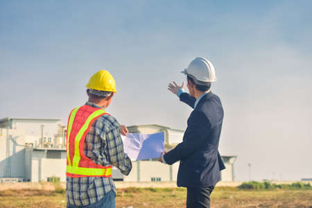 Asian team Construction engineers supervising progress of construction project stand on new factory, Engineering Consulting People on construction site Building inspector.の写真素材