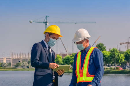 Asian team Construction engineers supervising progress of construction project stand on new factory, Engineering Consulting People on construction site Building inspector.の写真素材