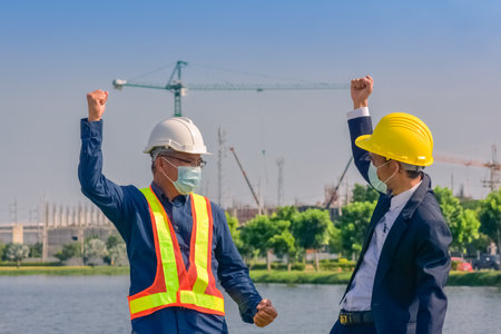 Asian team Construction engineers supervising progress of construction project stand on new factory, Engineering Consulting People on construction site Building inspector.の写真素材