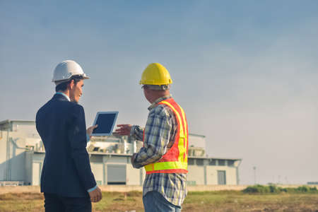 Asian team Construction engineers supervising progress of construction project stand on new factory, Engineering Consulting People on construction site Building inspector.の写真素材