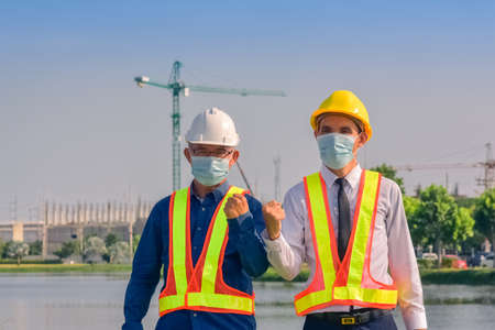 Asian engineer and foreman worker with touch pad discuss, plan working for the outdoors building construction site.の写真素材