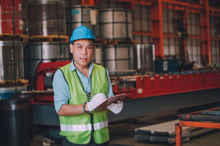 Asian man engineer  working hard in factory , worker employee  hard hat safety control machine factoryの写真素材