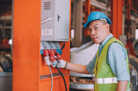Asian man engineer  working hard in factory , worker employee  hard hat safety control machine factoryの写真素材