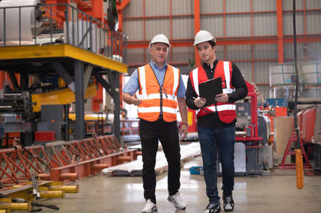 Two people staff audit team checking safety in factory, Engineer talking training coworker team companyの写真素材