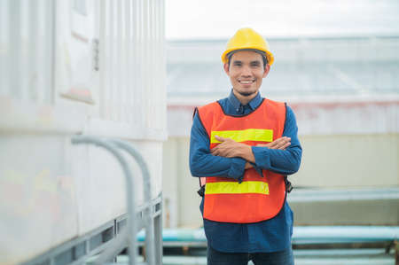 Confident Asian engineer standing in  factory , Asia worker employee in hard hat safety work in factoryの写真素材