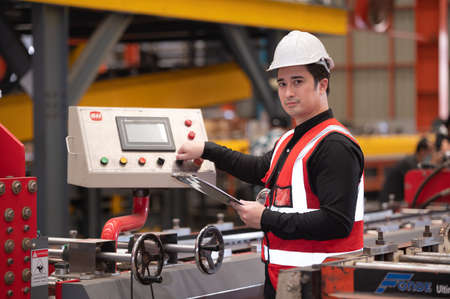 Asian man engineer  working hard in factory , worker employee  hard hat safety control machine factoryの写真素材