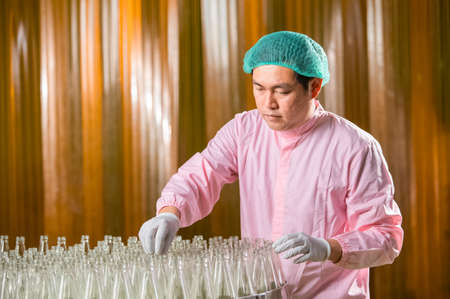 Asian man employee working Food quality control in Factory and worker inspecting production line beverage tanker in of dairy factory Concept food industryの写真素材