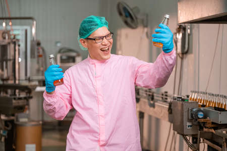 Asian man employee working Food quality control in Factory and worker inspecting production line beverage tanker in of dairy factory Concept food industryの写真素材