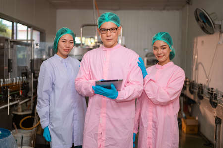 Teamwork Asian manager and employee working Food quality control in Factory and worker in production line beverage factory Concept food factory industryの写真素材