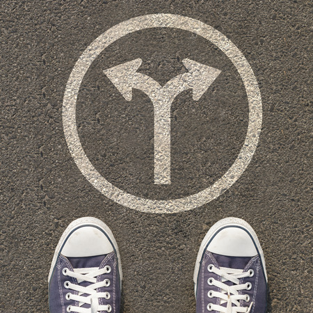 Pair of shoes standing on a road with traffic signの写真素材