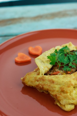 stuffed omelette, Omelet with vegetable salad and Heart-shaped carrot, on blue old woodenの写真素材