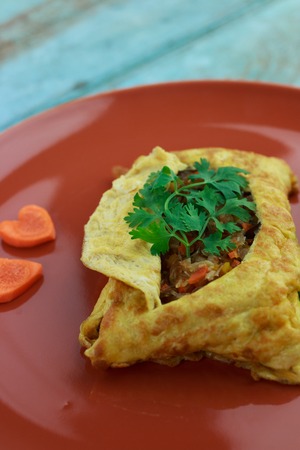 stuffed omelette, Omelet with vegetable salad and Heart-shaped carrot, on blue old woodenの写真素材
