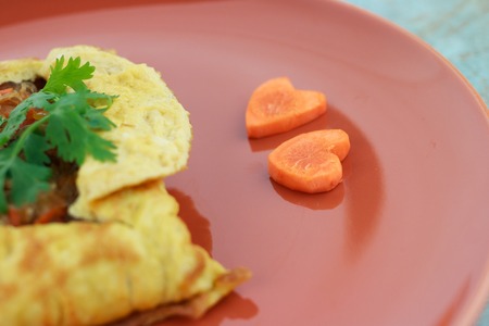 stuffed omelette, Omelet with vegetable salad and Heart-shaped carrot, on blue old woodenの写真素材