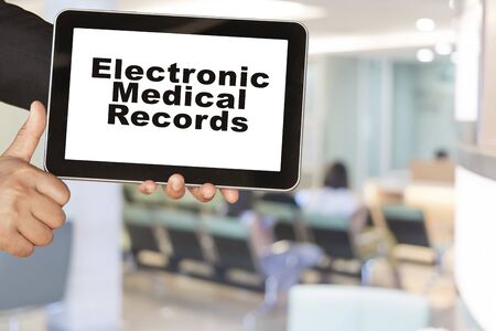 Medical record system show on tablet in someone hand on blur hospital background.の写真素材