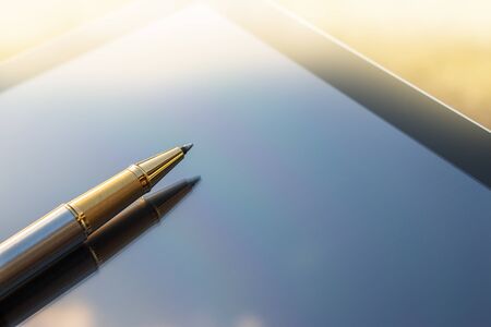 Low angle view of golden pen lying on tabletの写真素材
