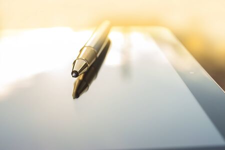 Low angle view of golden pen lying on tabletの写真素材