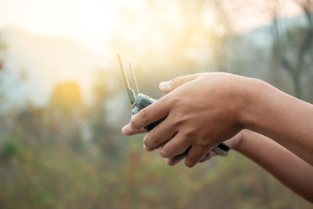 hands with remote controller of drone outside.