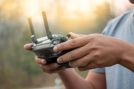 hands with remote controller of drone outside.
