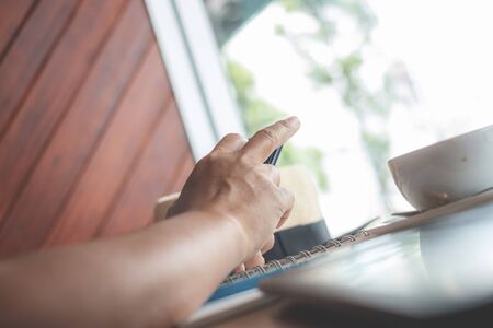 Woman typing text message on smart phone in a cafe.の写真素材