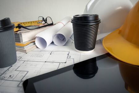 The architect's office in the design office has a blueprint, safety hat and architects' tools.の写真素材