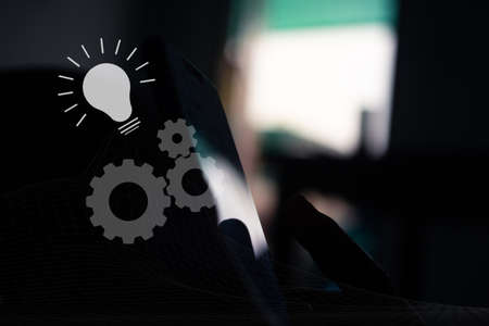 Interlocking cogs lead to good ideas, virtual dashboard diagrams on the smartphone background.の写真素材