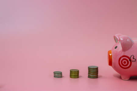 Pink piggy bank and coins on pastel pink background, Financial conceptsの写真素材