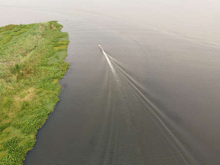 A fishing boat was sailing in a large lagoon.の写真素材