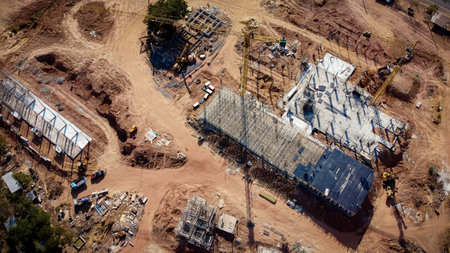 Aerial view The project is constructing a large building. Yellow construction crane and workers are...