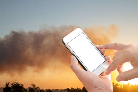 Conception of emergency notification with technology, Fire with black smoke floated on sunset sky.の写真素材