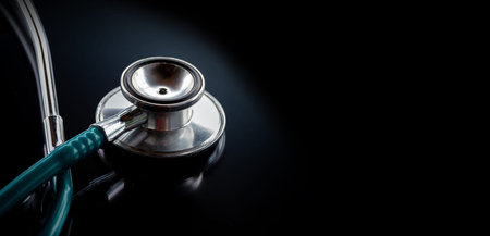Stethoscope on a glass table, dark background, The concept of medicine and medical treatment