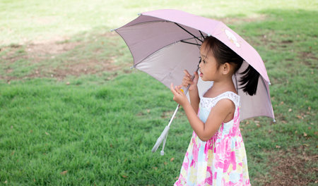 A girl with a pink parasol in the parkの写真素材