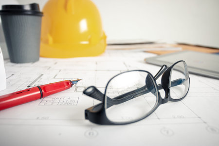 The architect's office in the design office has a blueprint, safety hat and architects' tools.