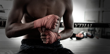 Male boxers wrapped their hands with orange cloth to prepare to fightの写真素材