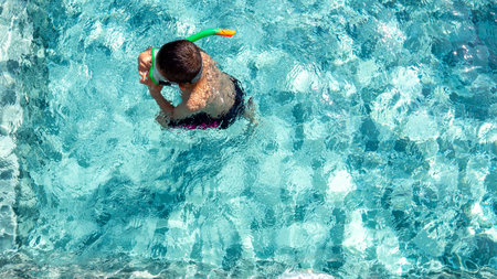 The boy is very happy to swim in the pool. Family vacation conceptの写真素材