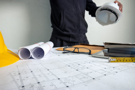 The architect is working to design the building at the office desk.