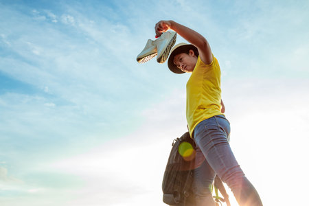 The woman left the work shoes and wore sneakers on the highway with the golden light of the sun....