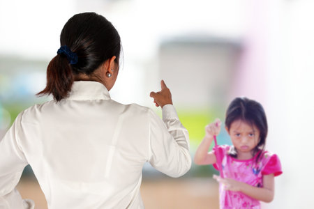 Mother scolds her child because of playing naughty and refusing to obeyの写真素材