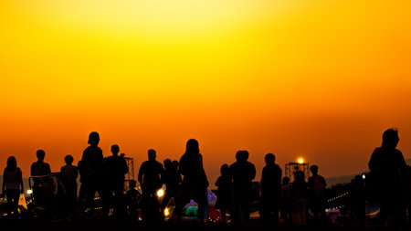 Silhouette of many tourists are taking pictures by smart phone on the top of the mountain during sunset times.の写真素材