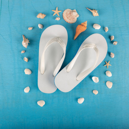 Summer beach sea accessories. flip flops, shells, starfish on blue background top view flat lay copy space. Summer background Holiday vacation travel conceptの写真素材