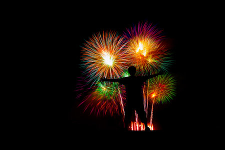 Silhouette successful man at the peak, Beautiful colorful fireworks display on the sea beach.の写真素材