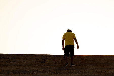 The young man on top of the stairs going to the sunset sky, Ambitions concept and Successful.の写真素材