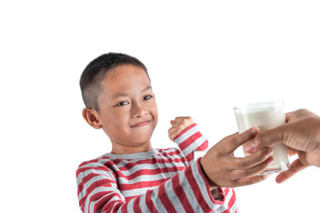 Concept of healthy milk drinking, The little boy is happy with a glass of milk received from a parent.の写真素材