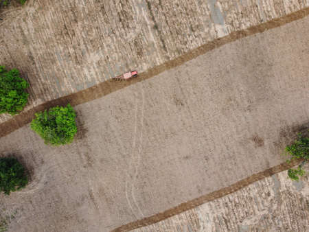 Drone Photos, Agricultural machines are working on agricultural plots.の写真素材