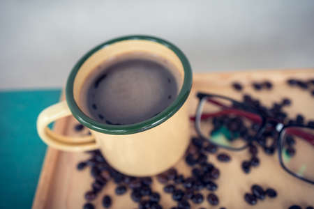 Yellow coffee cup on the desk, refreshing coffee.の写真素材