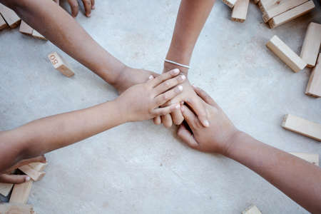 Diverse children hands are join together on the concrete backgroundの写真素材