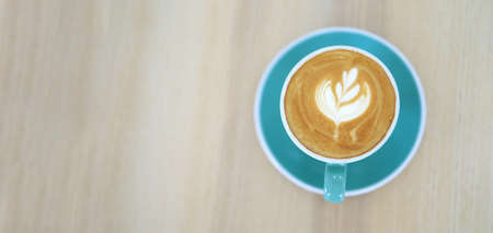 A coffee mug with latte art in a coffee shop.の写真素材