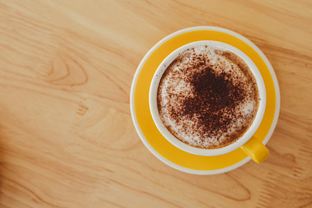 yellow coffee mugs on wooden table in cafe