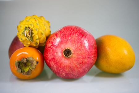 Exotic fruit, khaki, mango, pitahaja, pomegranate on a white background - studioの写真素材