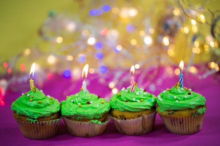 muffin with green buttercream, pink background, candleの写真素材