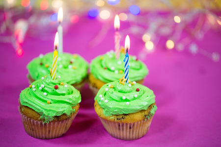 muffin with green buttercream, pink background, candleの写真素材